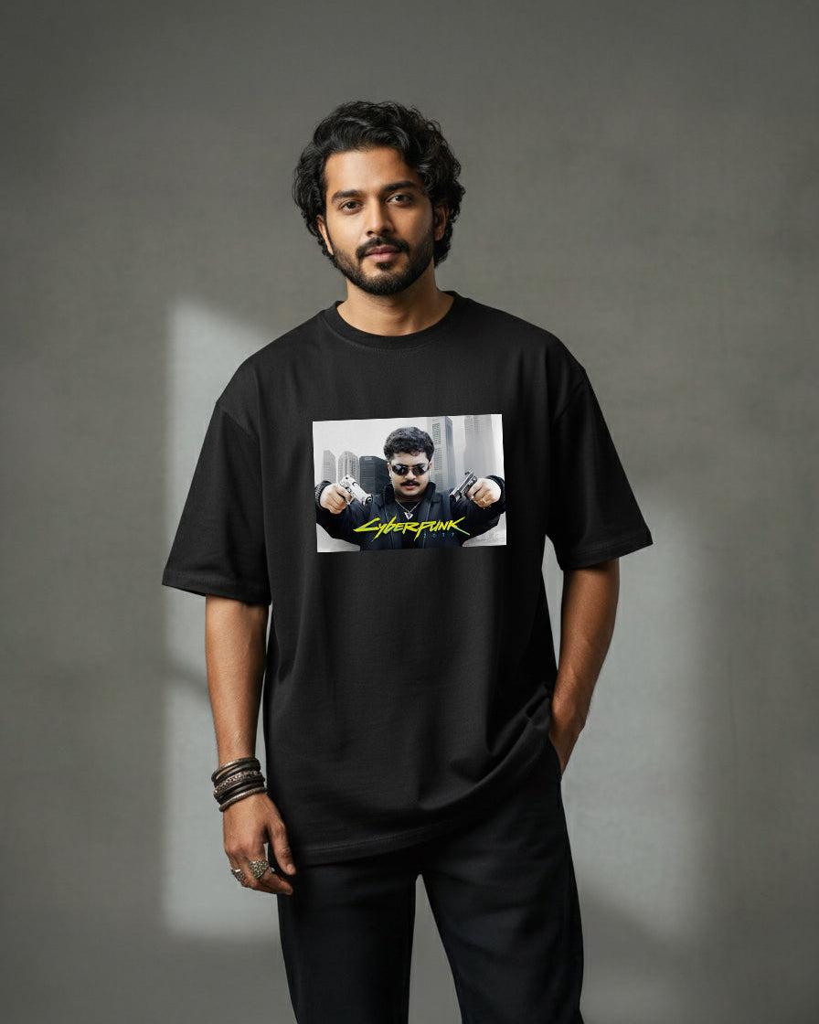 A man with dark hair and a beard stands against a gray backdrop, wearing the Cyberpunk VINU oversized black t-shirt made from 220 GSM heavyweight fabric, featuring a graphic of a man in sunglasses with fists raised above the word Superfunk.